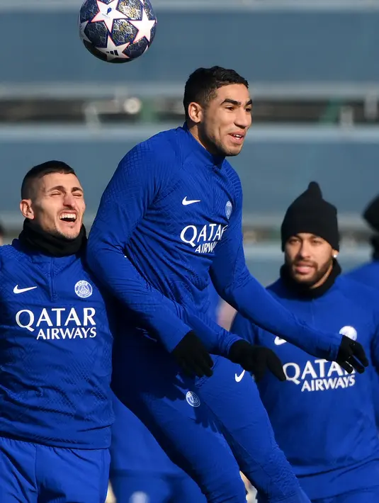 Bek PSG, Achraf Hakim berebut bola dengan Gelandang Marco Verratti selama sesi latihan di Saint-Germain-en-Laye, sebelah barat Paris pada 13 Februari 2023. PSG akan bertanding melawan wakil Jerman Bayern Muenchen pada pertandingan babak 16 besar Liga Champions. (AFP/Franck Fife)