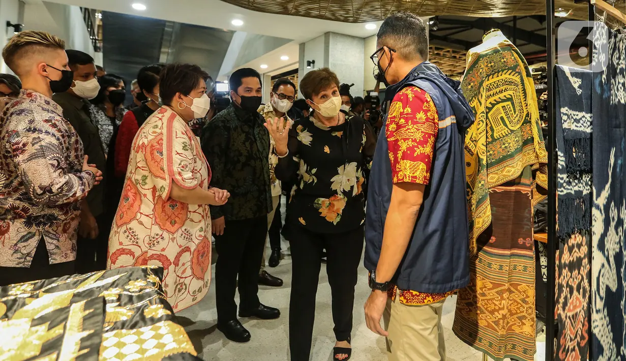 Direktur Pelaksana Dana Moneter Internasional (IMF) Kristalina Georgieva yang didampingi Menteri BUMN Erick Thohir bersama Menteri Pariwisata dan Ekonomi Kreatif (Menparekraf), Sandiaga Uno melihat produk-produk yang dijual saat mengunjungi Gedung Sarinah, Jakarta, Minggu (17/7/2022). (Liputan6.com/Johan Tallo)