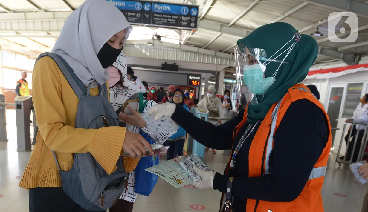 Petugas gabungan membagikan masker kepada calon penumpang  KRL jurusan Jakarta- Bogor di stasiun Tebet, Jakarta, Kamis (27/8/2020). Kegiatan tersebut merupakan rangkaian dari kampanye menggunakan masker di era Adaptasi Kebiasaan Baru untuk menghindari penularan COVID-19. (merdeka.com/Imam Buhori)