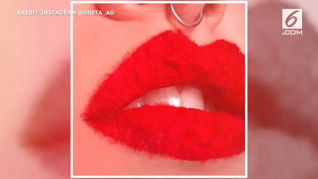 Greta menempelkan bulu berwarna senada lipstik pada bibirnya hingga menampilkan tampilan yang unik.