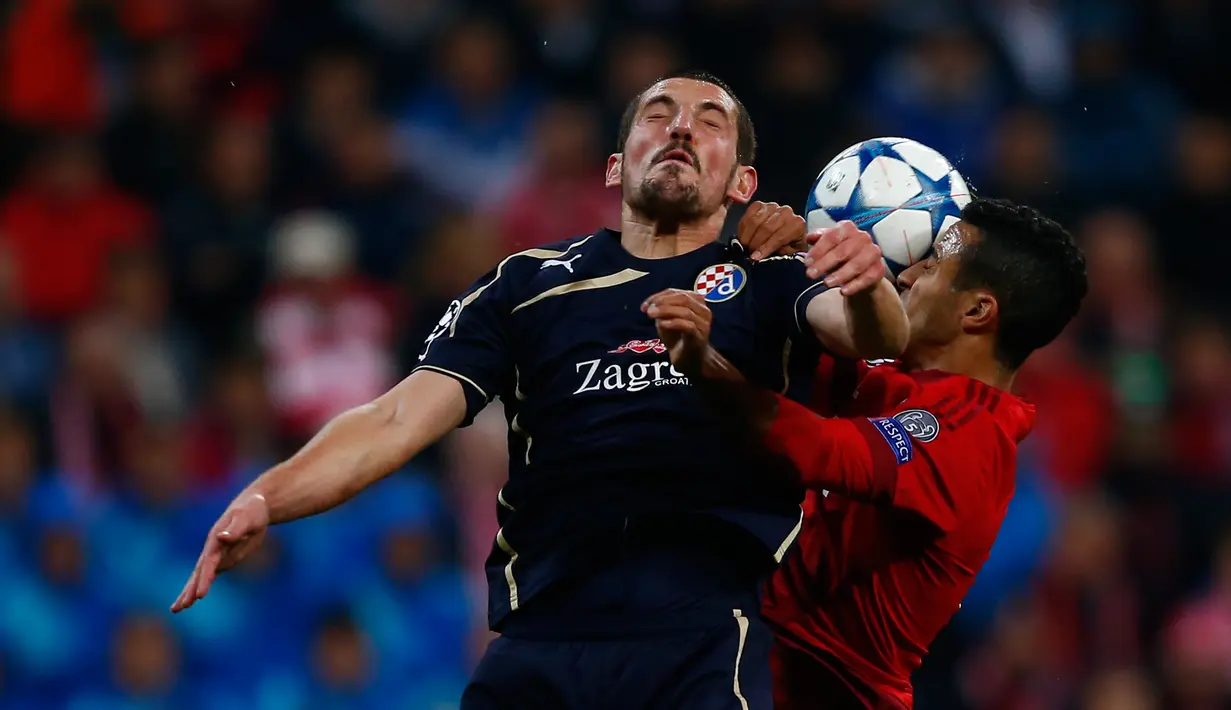 Gelandang Dinamo Zagreb, Arijan Ademi berubut bola udara dengan gelandang Muenchen, Thiago Alcantara pada laga Liga Champions di Allianz Arena, Jerman (30/9/2015). Muenchen menang telak atas Dinamo Zegreb dengan skor 5-0. (REUTERS/Michael Dalder)
