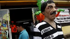Sebuah patung dikenakan topeng gembong narboka "El Chapo" Guzman di pinggir jalanan kota Meksiko, Kamis (15/10/2015). Topeng gembong narkoba "El Chapo" diperjualkan menjelang Halloween. (REUTERS/Henry Romero)