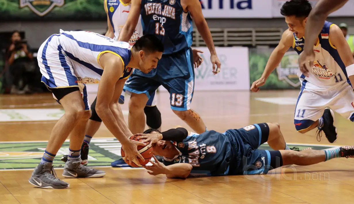 Pemain Satria Muda, Christian Sitepu (kiri) merebut bola dari pemain Pelita Jaya, Faisal yang terjatuh pada gim kedua final IBL 2017 di di Britama Arena, Kelapa Gading, Sabtu (6/52017). Satria Muda menang 83-63. (Bola.com/Nicklas Hanoatubun)