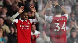 Selebrasi gelandang Arsenal, Reiss Nelson bersama rekannya, Granit Xhaka setelah mencetak gol ke gawang Nottingham Forest dalam laga Liga Inggris 2022/2023 di Emirates Stadium, London (30/10/2022). Reiss Nelson dipromosikan ke tim utama Arsenal pada awal musim 2019/2020, namun akibat kalah bersaing ia lebih banyak dicadangkan. Musim ini ia baru kembali dari satu tahun masa peminjaman bersama Feyenoord. (AFP/Ian Kington)