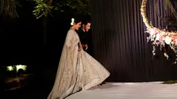Aktris Bollywood Priyanka Chopra dan musisi AS Nick Jonas berjalan saat resepsi pernikahan mereka di New Delhi, India, Selasa (4/12). Priyanka Chopra dan Nick Jonas menikah dalam dua upacara yang berbeda. (AP Photo/Altaf Qadri)