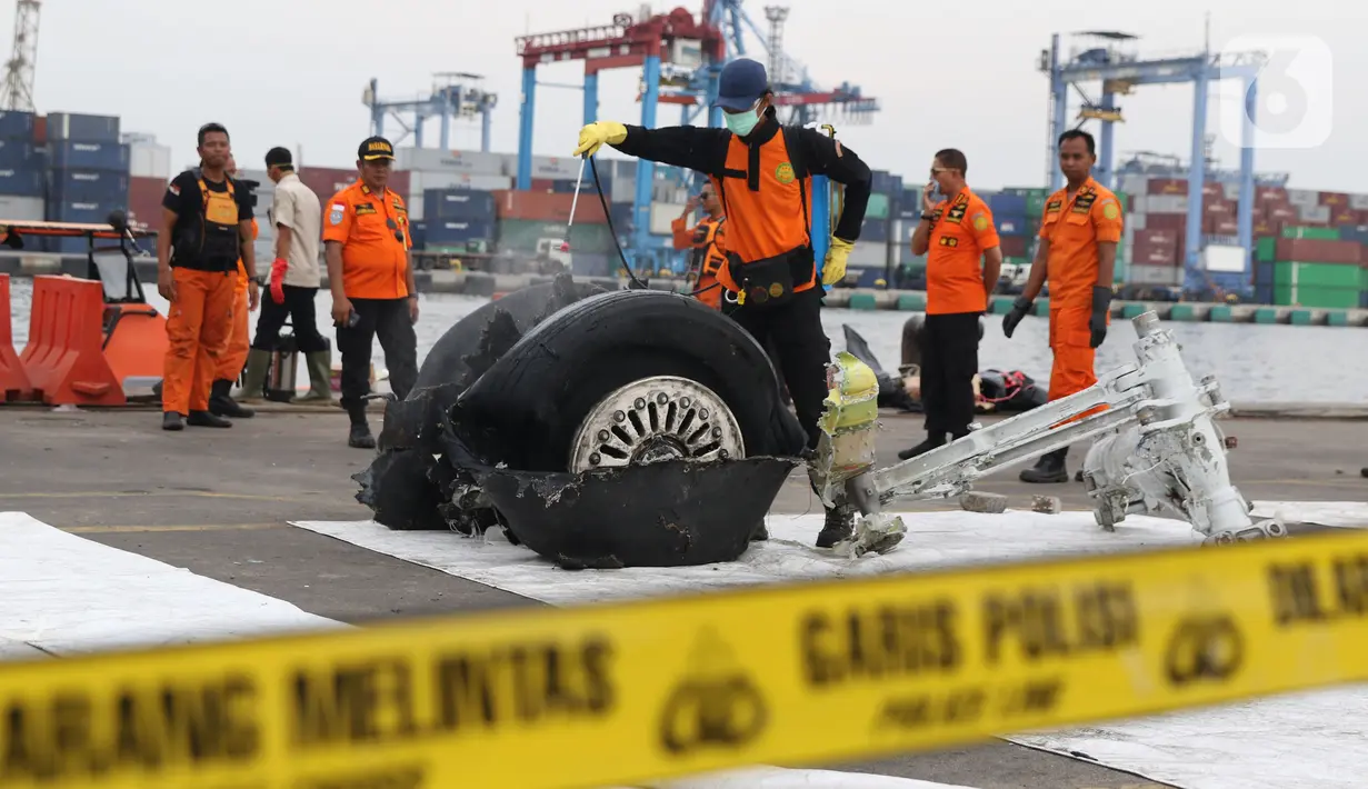 File foto pada 5 November 2018 memperlihatkan petugas menyemprot cairan pada bagian roda pesawat Lion Air PK-LQP JT 610 di Pelabuhan JICT 2, Jakarta. Bagian tersebut dipindah untuk dilakukan identifikasi dan pengecekan lebih lanjut oleh KNKT. (Liputan6.com/Helmi Fithriansyah)