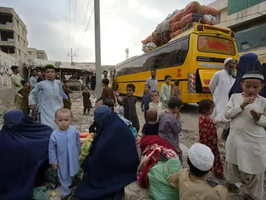 Keluarga Afghanistan menunggu naik bus untuk berangkat ke tanah air mereka, di Karachi, Pakistan, Jumat, 6 Oktober 2023. (AP Photo/Fareed Khan)