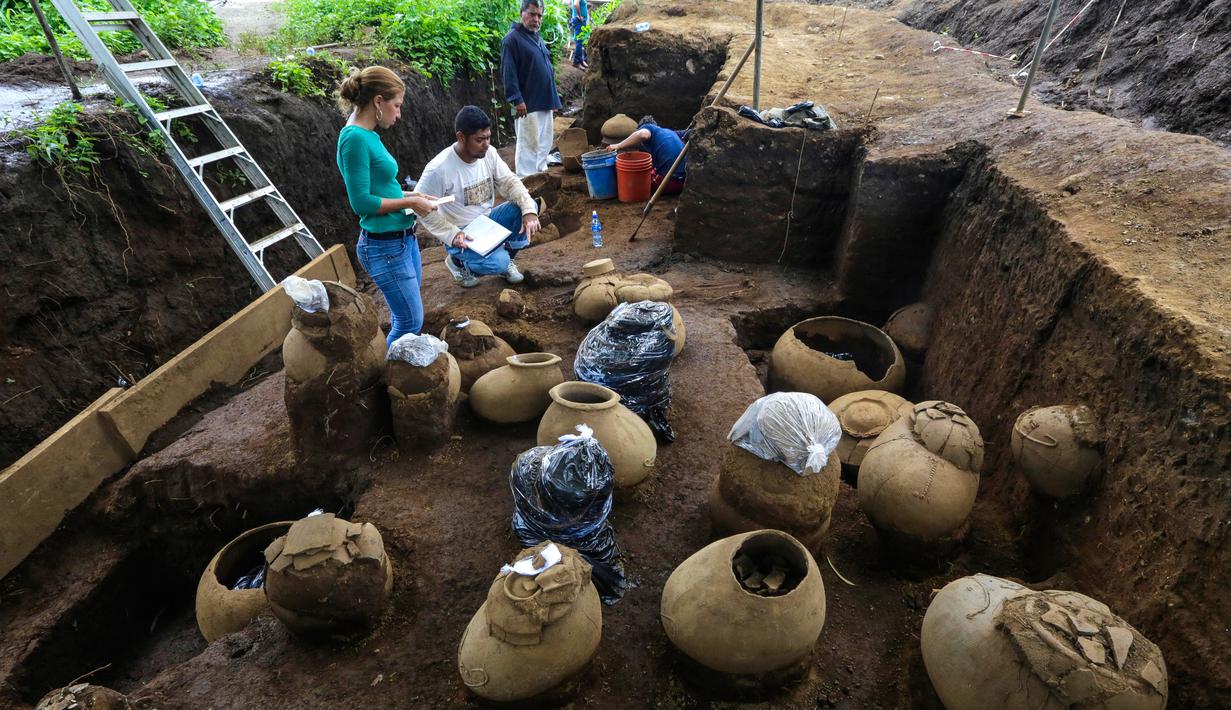 Pekerja Nicaraguan Institute of Culture (INC) mendata sejumlah tembikar di situs pemakaman zaman pra-Kolombia berusia lebih dari 1.200 tahun yang ditemukan di lokasi pembangunan Stadion Bisbol Nasional yang baru di Managua, Selasa (20/6). (INTI OCON/AFP)