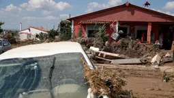 Orang-orang berdiri di balkon rumah yang terendam banjir yang dipicu badai dan hujan deras di desa Bourtzi di pulau Evia, Yunani, Senin (10/8/2020). Satu orang masih hilang, sementara banjir memblokir jalan serta merusak rumah-rumah di pulau di timur laut Athena itu. (AP Photo/Thanassis Stavrakis)