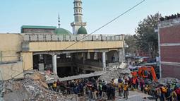 Petugas penyelamat mencari korban ledakan di puing-puing masjid yang rusak di dalam markas besar polisi di Peshawar, Pakistan, Senin (30/1/2023). Perdana Menteri Shehbaz Sharif mengutuk keras serangan tersebut. Dalam sebuah pernyataan, ia mengatakan bahwa mereka yang berada di balik insiden tersebut "tidak ada hubungannya dengan Islam". (Abdul MAJEED/AFP)