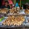 Seorang penjual ikan asap menunggu pelanggan di Surabaya, Jawa Timur, Rabu 6 Mei 2026. Menteri Usaha Mikro, Kecil, dan Menengah (UMKM) Maman Abdurrahman menyampaikan, pada Selasa (5/5/2026), hingga 3 Mei 2026, penyaluran Kredit Usaha Rakyat (KUR) kepada sektor usaha mikro mencapai sekitar Rp 70 triliun. (JUNI KRISWANTO/AFP)
