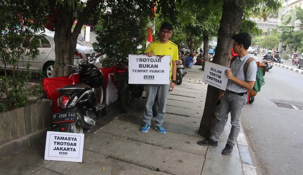 Koalisi Pejalan Kaki menunjukkan poster yang berisi imbauan saat melakukan aksi Tamasya Trotoar Kita di Jalan Medan Merdeka Selatan, Jakarta, Minggu (24/6). Acara ini juga dilakukan untuk mememperingati HUT Jakarta ke-491. (Liputan6.com/Arya Manggala)
