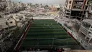 Sebuah pertandingan sepak bola lima lawan lima menarik perhatian warga Palestina di tengah kekerasan yang terus berlanjut di wilayah Gaza. Tampak dalam foto, warga Palestina menyaksikan pertandingan sepak bola lima lawan lima di tengah reruntuhan bangunan yang hancur di Kota Gaza pada Senin 9 Februari 2026. (Omar AL-QATTAA/AFP)
