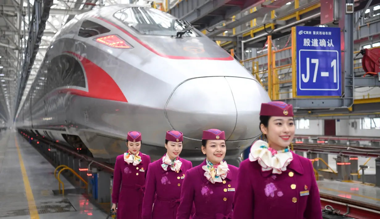 Sejumlah awak pengoperasian pertama kereta peluru Fuxing CR400AF berpose di depan kereta di stasiun pemeliharaan depo gerbong kereta di Kota Chongqing, China barat (23/12/2020). (Xinhua/Tang Yi)