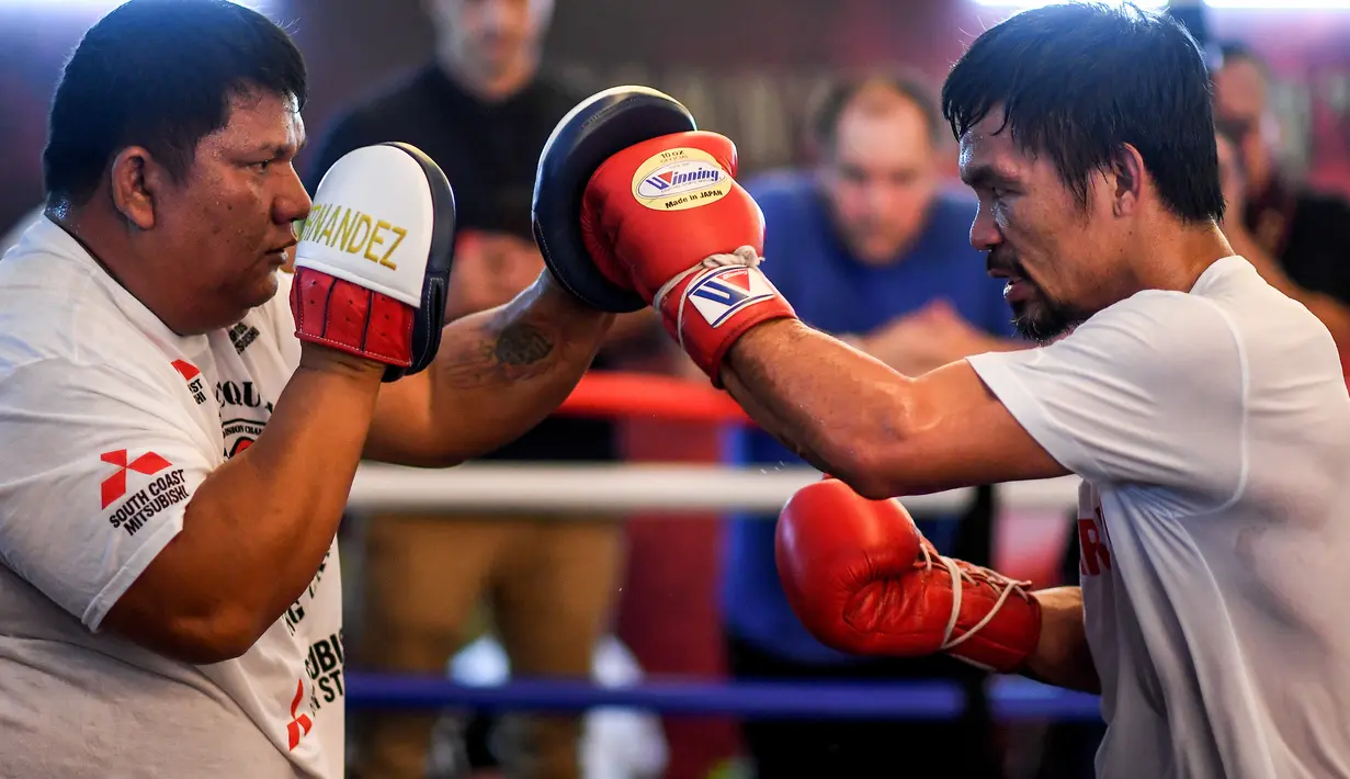 Petinju asal Filipina, Manny Pacquiao (kanan) berlatih selama sesi pelatihannya di sebuah gym di Kuala Lumpur, Malaysia (11/7). Manny Pacquiao akan bertanding pada kelas welter melawan petinju Argentina Lucas Matthysse. (AFP Photo/Mohd Rasfan)