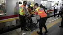 Petugas membantu penyandang disabilitas naik ke kereta saat menjajal fasilitas di Stasiun Jatinegara, Jakarta, Jumat (3/12/2021). KAI Commuter mengajak pengguna transportasi dengan disabilitas untuk merasakan sarana dan prasarana perkeretaapian yang lebih aksesibel. (Liputan6.com/Faizal Fanani)