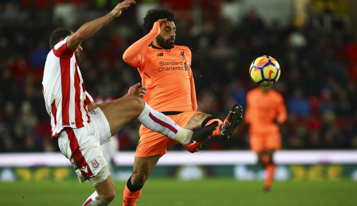 Gelandang Liverpool, Mohamed Salah, berebut bola dengan bek Stoke, Erik Pieters, pada laga Premier League di Stadion Bet365, Stoke-on-Trent, Rabu (29/11/2017). Stoke kalah 0-3 dari Liverpool. (AFP/Geoff Caddick)