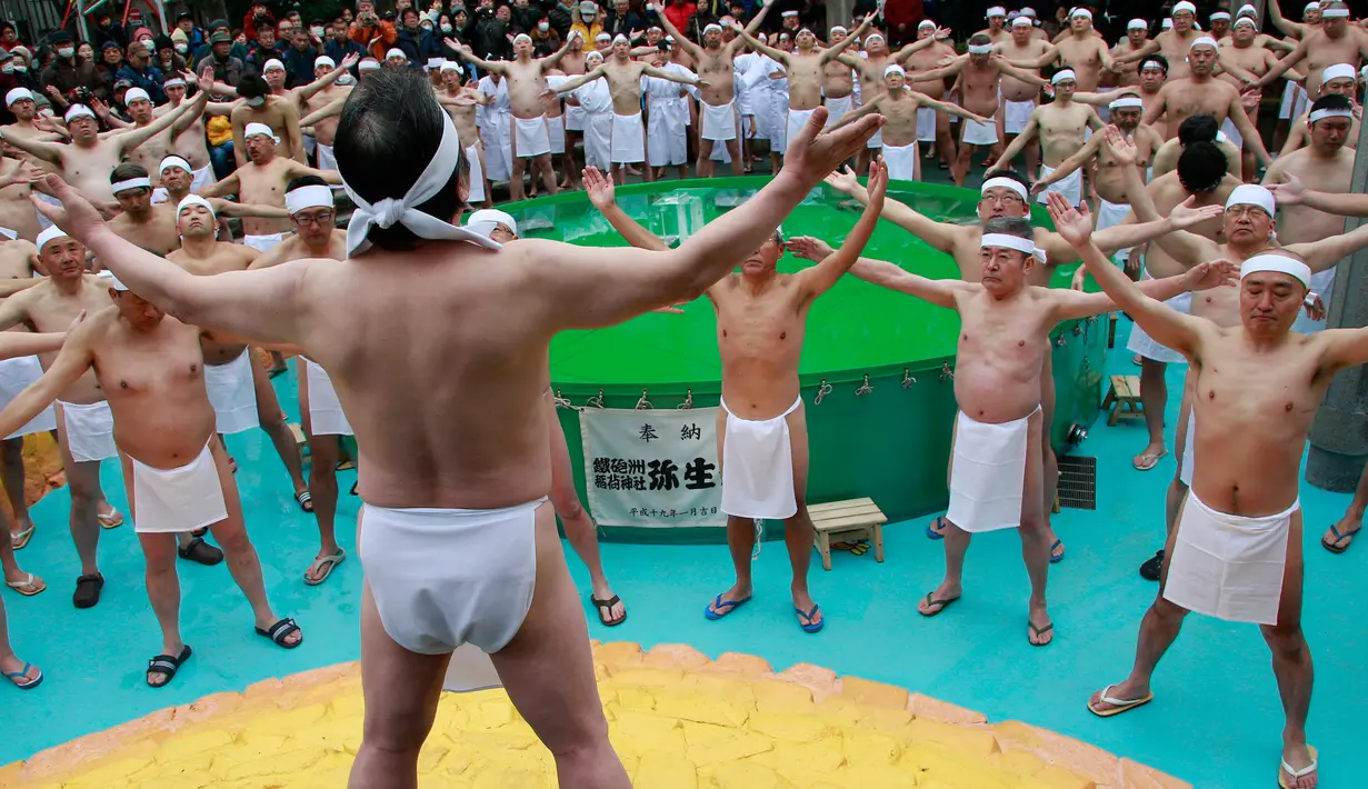 Para peserta melaukan persiapan sebelum berendam di dalam kolam air dingin di Teppozu Inari Shinto Shrine di Tokyo, Jepang (8/1). Mandi air dingin ini diikuti sekitar 100 orang. (AP Photo/Shizuo Kambayashi)