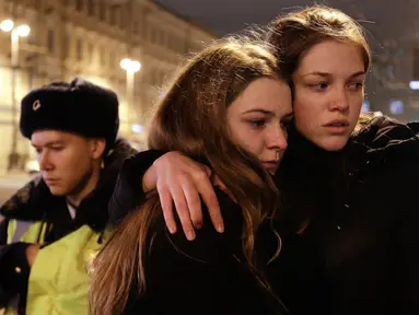 Dua warga berpelukan saat berduka di dekat lokasi ledakan bom di stasiun kereta bawah tanah St. Petersburg, Senin (3/4). Dikabarkan kejadian tersebut menewaskan 10 orang dan menghancurkan sebuah gerbong kereta. (AP Photo / Dmitri Lovetsky)