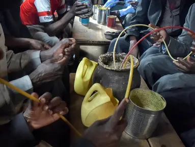 Sejumlah pria meminum air beralkohol dari pot yang disebut Busaa di daerah Nairobi, Kenya, Rabu (8/11). Minuman ini adalah bir tradisional Kenya yang terbuat dari dari tepung sorgum, jagung, atau tepung millet. (AFP Photo/Simon Maina)