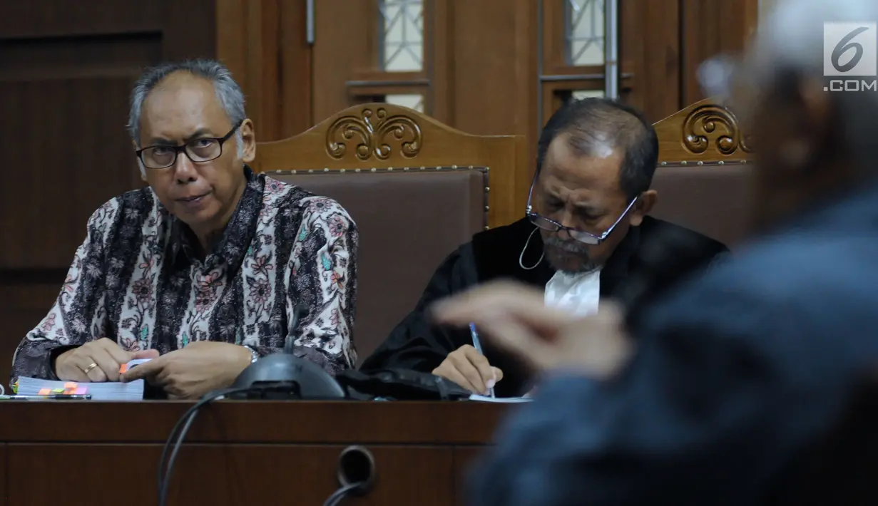 Terdakwa perkara merintangi penyidikan dugaan korupsi E-KTP, Bimanesh Sutarjo (kiri) menyimak keterangan saksi saat mengikuti sidang lanjutan di Pengadilan Tipikor, Jakarta, Senin (16/4). Sidang mendengar keterangan saksi.(Liputan6.com/Helmi Fithriansyah)