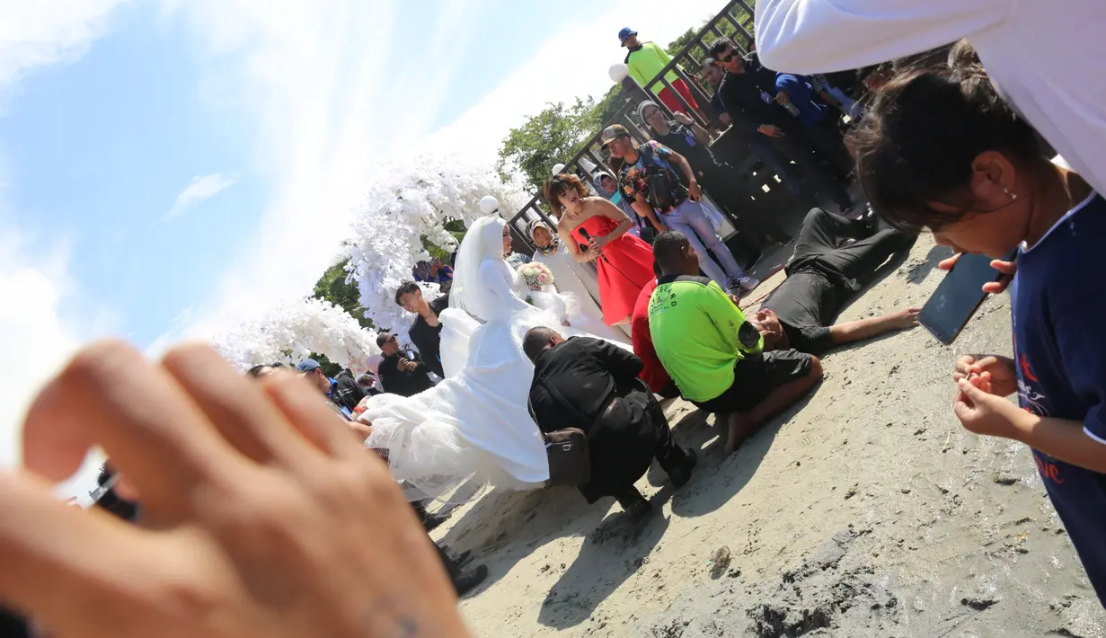 Vicky Prasetyo kelelahan hingga akhirnya pingsan. Pengantin tersebut pingsan dibibir pantai kawasan Ancol Beach City. Angel Lelga panik menyaksikan suaminya. Entah itu pingsan bener atau hanya membuat kejutan lagi? (Nurwahyunan/Bintang.com)