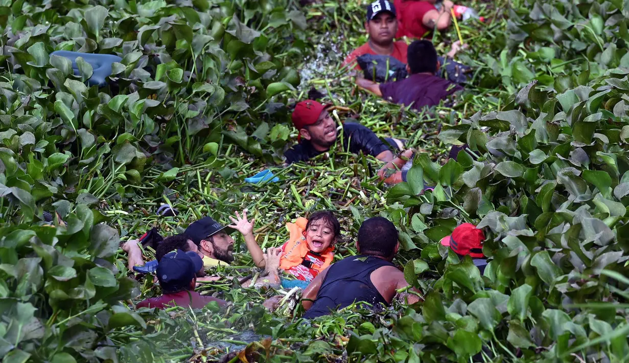 Para migran menyeberangi tepi Sungai Rio Grande menuju Amerika Serikat, seperti yang terlihat dari Matamoros, negara bagian Tamaulupas, Meksiko pada tanggal 9 Mei 2023. Peraturan di era pandemi yang melarang para migran untuk mengajukan suaka ke AS berakhir pada Kamis (9/5) malam. Kebijakan baru ini menimbulkan ketidakpastian bagi ribuan orang yang mencari perlindungan di Amerika. (ALFREDO ESTRELLA/AFP)