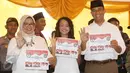 Calon Gubernur DKI Jakarta Anies Baswedan bersama istri, Fery Farhati, dan anak perempuannya menunjukkan surat suara sambil berpose salam 3 jari sebelum mencoblos di TPS 028 Cilandak Barat, Jakarta Selatan, Rabu (15/2). (Liputan6.com/Immanuel Antonius)