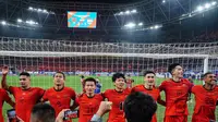 Sejumlah pemain China bernyanyi dengan para pendukung mereka setelah laga lanjutan putaran ketiga Grup C Kualifikasi Piala Dunia 2026 melawan Timnas Indonesia di Qingdao Youth Stadium, Qingdao, China, Selasa (15/10/2024). (AFP)