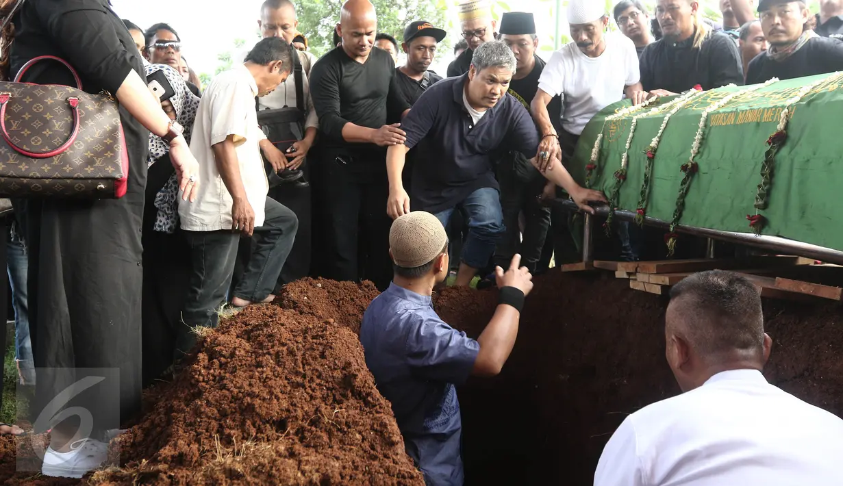 Suami Renita Sukardi, Andi Hilmi saat memasuki liang lahat di TPU Menteng Pulo, Jakarta, Senin (10/4). Menurut Hilmi, Renita sudah pasrah dan siap dipanggil Tuhan kapan saja. (Liputan6.com/Herman Zakharia)  