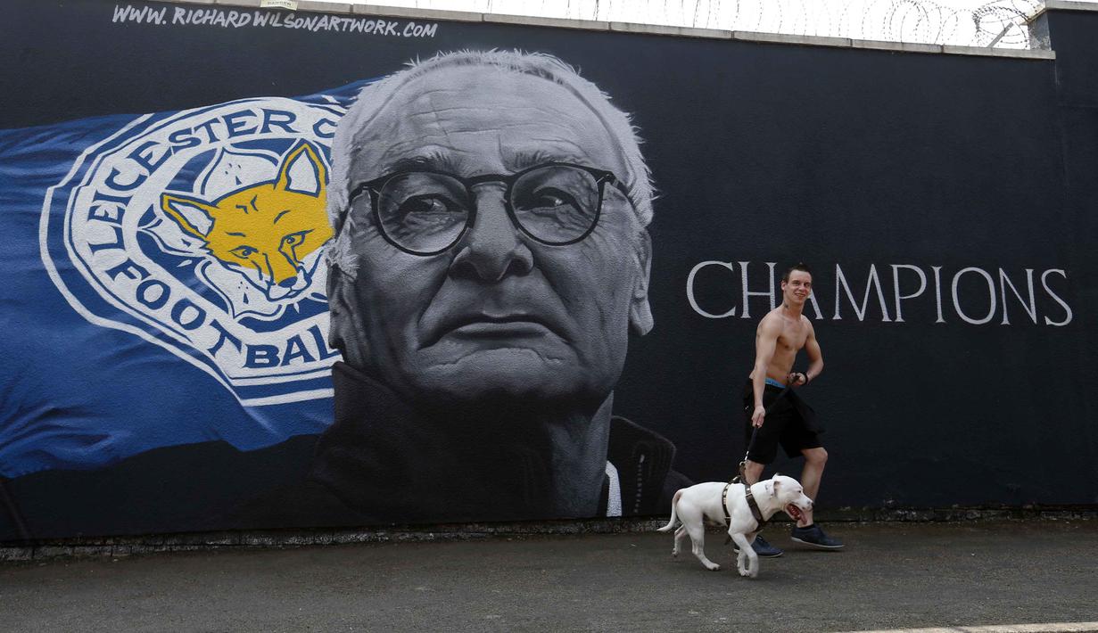Seorang Suporter berfoto bersama anjingnya dekat tembok bergambar pelatih Leicester City, Claudio Ranieri dekat Stadion King Power (7/5/2016). (Action Images via Reuters/Carl Recine)
