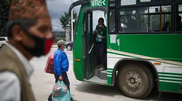 Calon penumpang bersiap naik bus di Kathmandu, Nepal (16/7/2020). Beberapa perusahaan angkutan umum di Lembah Kathmandu sudah mulai mengoperasikan kembali rute mereka untuk pertama kalinya dalam hampir empat bulan setelah menerima persyaratan operasional dari pemerintah. (Xinhua/Sulav Shrestha)