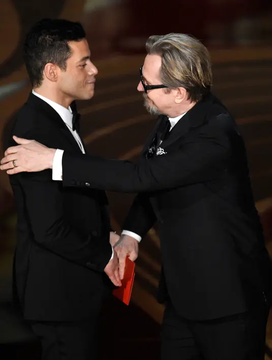 Gary Oldman memberikan penghargaan kepada Rami Malek di atas panggung Oscar 2019 di Dolby Theatre, Los Angeles, Minggu (24/2). Rami Malek meraih piala Oscar 2019 sebagai Aktor Pemeran Utama Terbaik di film Bohemian Rhapsody. (Chris Pizzello/Invision/AP)