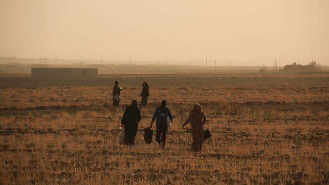 Warga melarikan diri dengan berjalan kaki saat pasukan Turki memburu milisi Kurdi di Ras al Ayn, Suriah, Rabu (9/10/2019). Presiden Turki Recep Tayyip Erdogan mengumumkan dimulainya operasi militer terhadap milisi Kurdi di timur laut Suriah. (AP Photo/Baderkhan Ahmad)