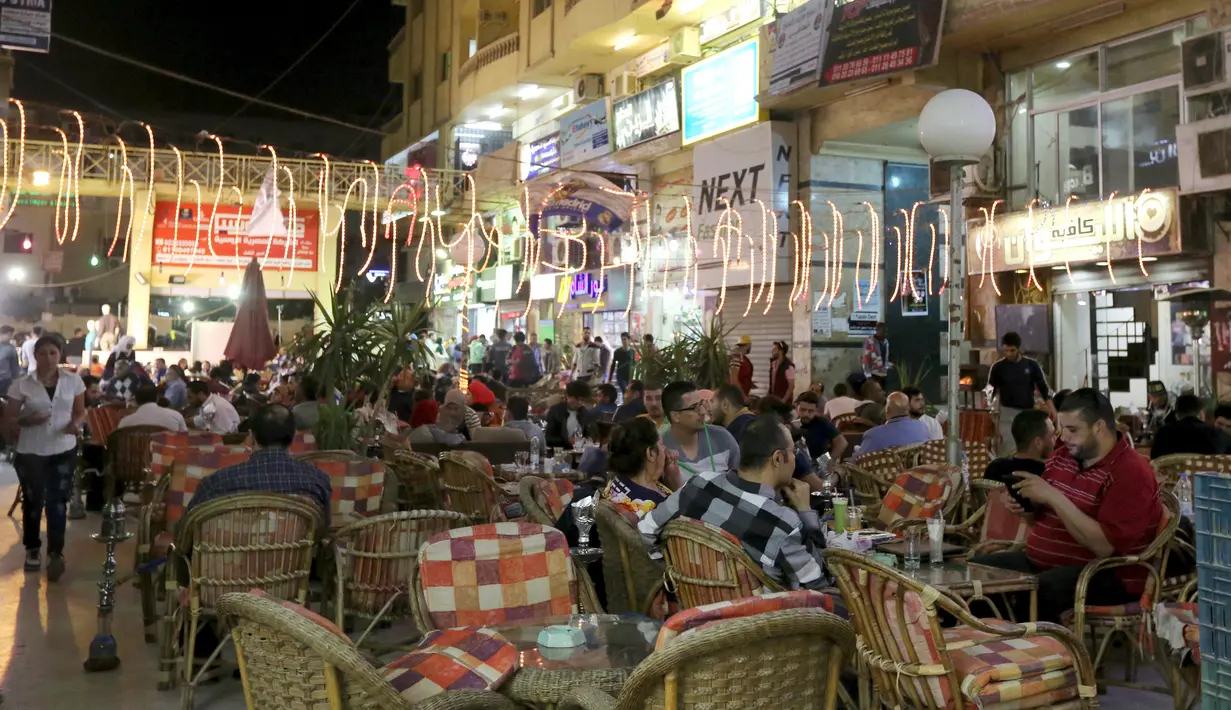 Warga Suriah bekerja di sebuah kedai kopi daerah bernama kota 6 Oktober, Giza, Mesir, (19/3). Menariknya di daerah ini sebagian pekerjanya merupakan imigran asal Suriah yang sedang mencari pekerjaan. (REUTERS / Mohamed Abd El Ghany)