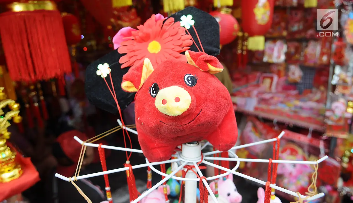 Boneka bertema Imlek dijual di kawasan Glodok, Jakarta, Kamis (31/1). Pernak-pernik Imlek bershio babi tanah sudah mulai ramai dijual. (Liputan6.com/Herman Zakharia)