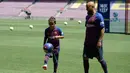 Pemain baru Barcelona, Arturo Vidal melihat putranya Alonso Vidal menunjukkan skill bermain bola selama presentasi dirinya di stadion Camp Nou, Spanyol, (6/8). (AFP Photo/Josep Lago)