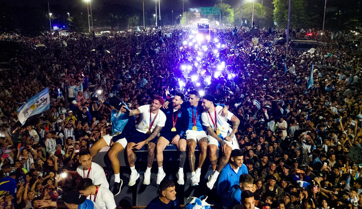 Lionel Messi dan kawan-kawan melakukan swafoto di atas bus saat parade juara Piala Dunia di kota Buenos Aires, Selasa (20/12/2020). (AFP/Tomas Cuesta)