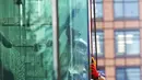 Seorang pekerja yang mengenakan masker untuk membantu mengekang penyebaran COVID-19 menyeka jendela sebuah gedung di Tokyo, Jepang, Senin (2/11/2020). Tokyo mengonfirmasi lebih dari 80 kasus baru COVID-19 pada 2 Oktober 2020. (AP Photo/Eugene Hoshiko)