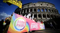 Para peserta memegang spanduk saat mengikuti Pride March tahunan di Roma, pada 11 Juni 2022. (Dok: Filippo MONTEFORTE / AFP)