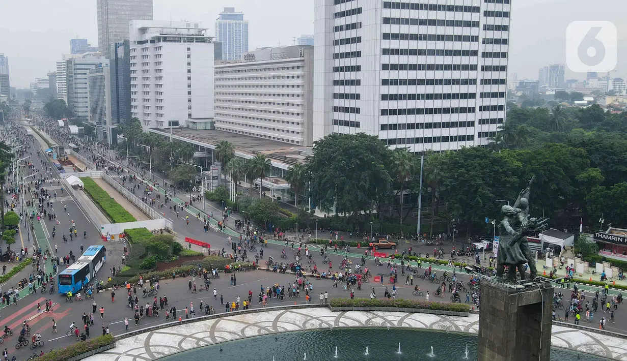 Foto udara aktivitas warga di kawasan Bundaran HI, Menteng, Jakarta Pusat, Minggu (22/5/2022). Pemprov DKI Jakarta kembali menggelar Hari Bebas Kendaraan Bermotor (HBKB) di sejumlah ruas jalan Ibu Kota. HBKB yang digelar pukul 06.00 – 10.00 tersebut dalam rangka meningkatkan kualitas udara di Jakarta. (Liputan6.com/Herman Zakharia)