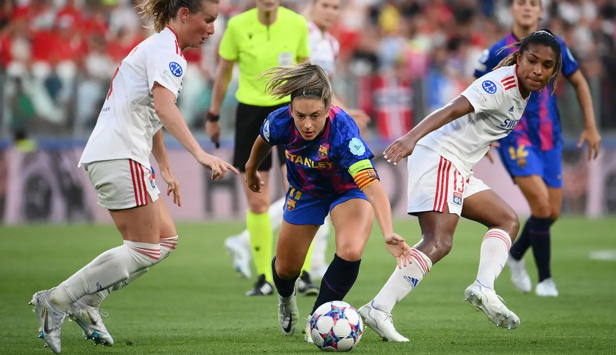 Pemain Barcelona, Alexia Putellas (tengah) berusaha melewati pemain Lyon pada final Liga Champions Wanita 2022/2023 di Allianz Stadium, Italia, 21 Mei 2022. (AFP/Franck Fife)