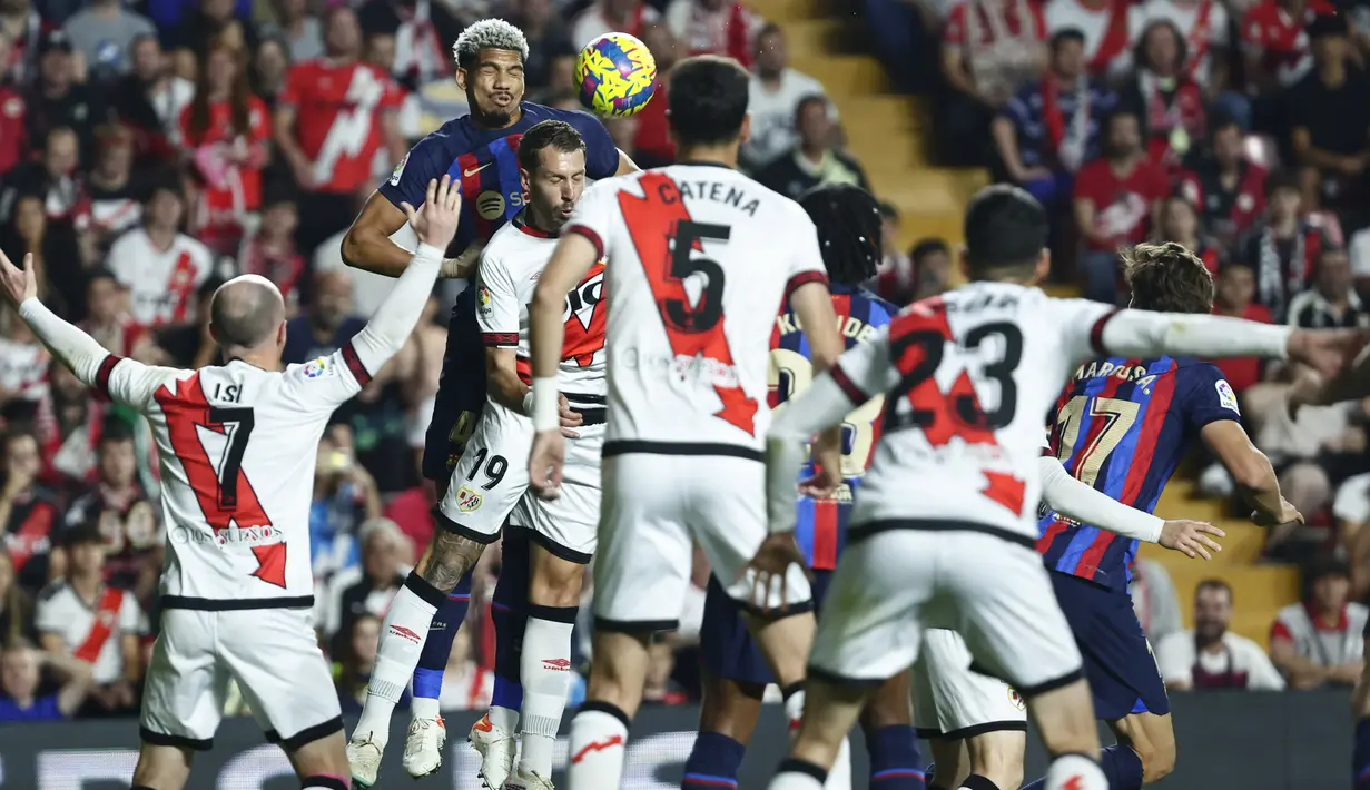 Pemain Barcelona, Ronald Araujo, menyundul bola saat melawan Rayo Vallecano pada laga Liga Spanyol di Stadion Vallecas, Kamis (27/04/2023). (AP Photo/Pablo Garcia)