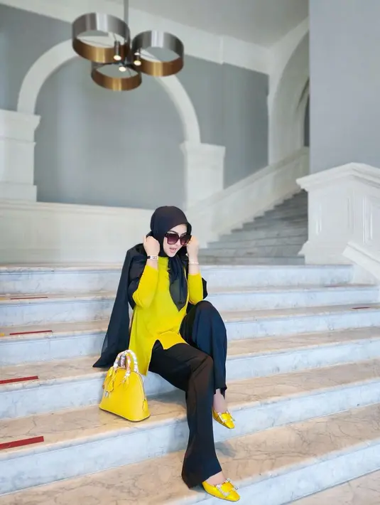 Lihat gaya chic Syahrini memadukan warna hitam dan kuning pada outfit dan tasnya. [Foto: Instagram/princessyahrini]