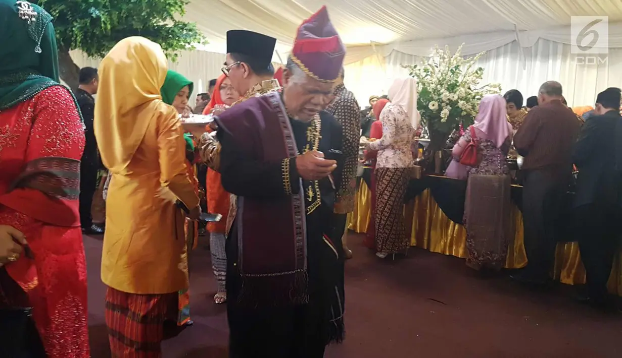 Seorang tamu undangan melihat ponselnya saat menghadiri pesta adat Kahiyang Ayu dan Bobby Nasution di di Bukit Hijau Regency Taman Setia Budi (BHR Tasbi), Medan, Sabtu (25/11). (Liputan6.com/Aditya Eka Prawira)