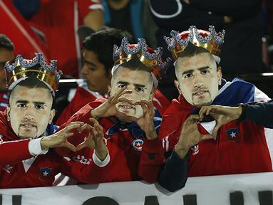 Suporter mengenakan topeng Arturo Vidal sebagai bentuk dukungan akan musibah kecelakaan yang dialaminya. (AP Photo/Luis Hidalgo)