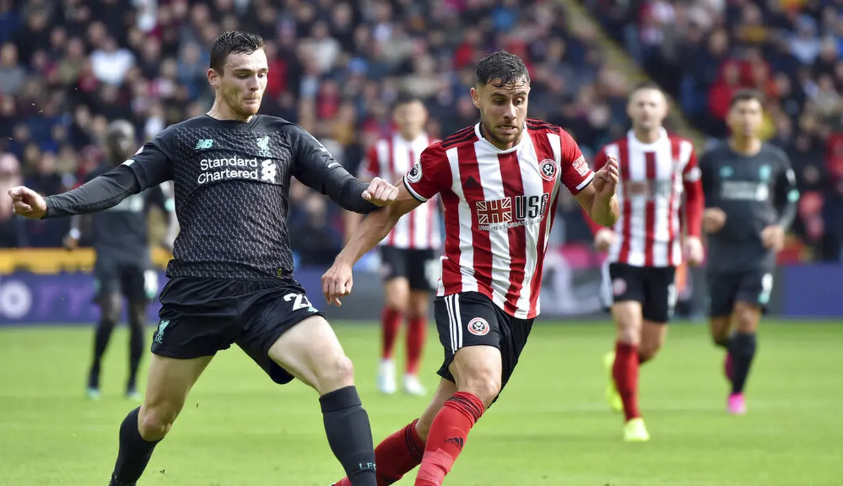 Bek Liverpool, Andrew Robertson, berebut bola dengan pemain Sheffield United, George Baldock, pada laga Premier League di Stadion Bramall Lane, Sabtu (28/9). Liverpool menang 1-0 atas Sheffield United. (AP/Rui Vieira)