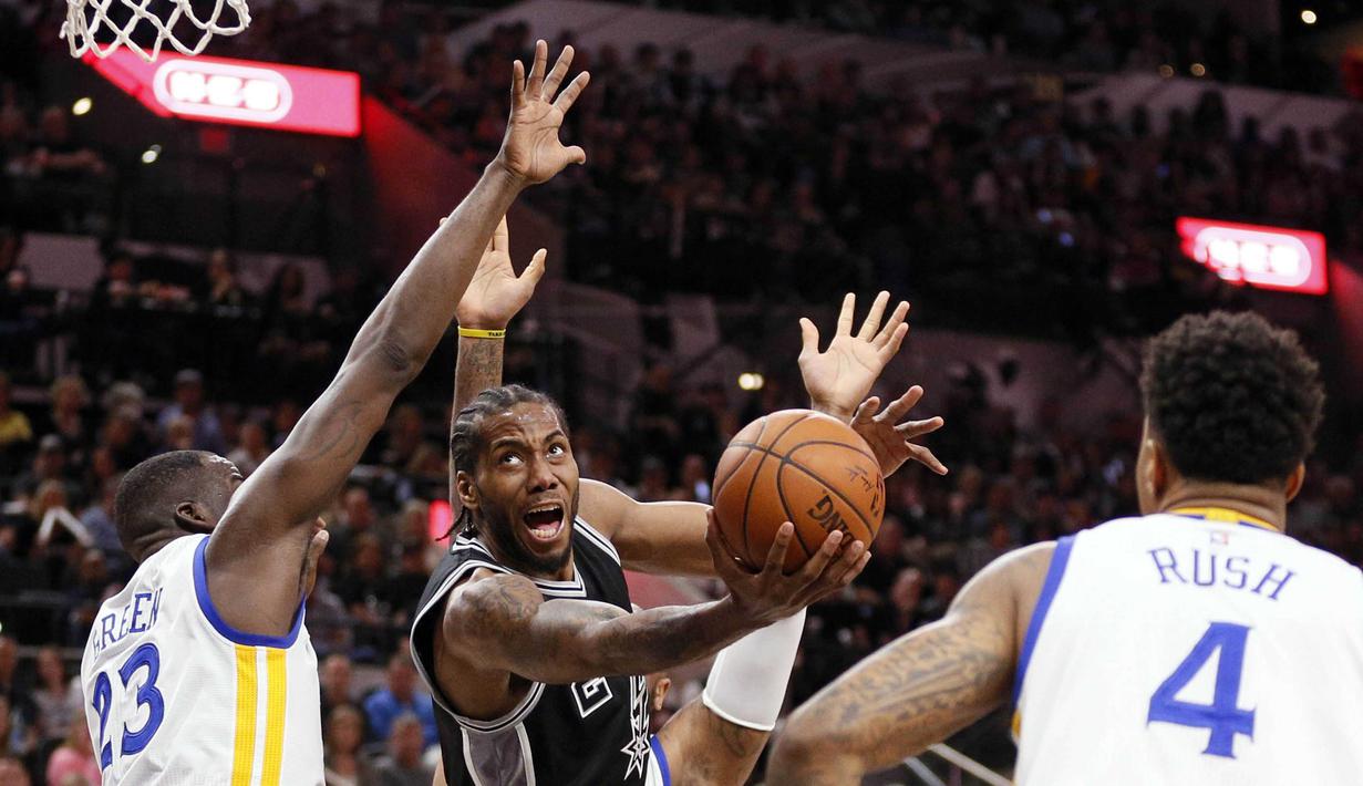 Pemain San Antonio Spurs, Kawhi Leonard (2), mencoba melewati hadangan para pemain Golden State Warriors pada lanjutan NBA di AT&T Center, San Antonio, AS, (10/4/2016). (Reuters/Soobum Im-USA Today Sports)