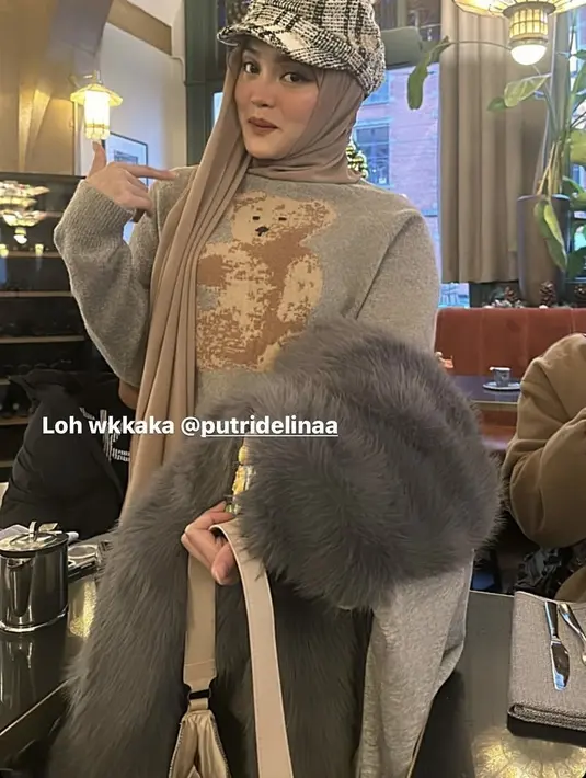 Putri Delina memadukan sweater tersebut dengan jaket bulu-bulu dan kerudung coklatnya. Seeta topi hotaknputohnya.  [@mahaliniraharja]