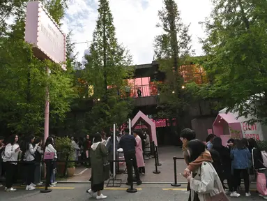 Penggemar mengantre untuk memasuki toko pop-up BTS di Distrik Gangnam, Seoul, Korea Selatan, Jumat (18/10/2019). Toko pop-up tersebut bernama House of BTS. (Jung Yeon-je/AFP)